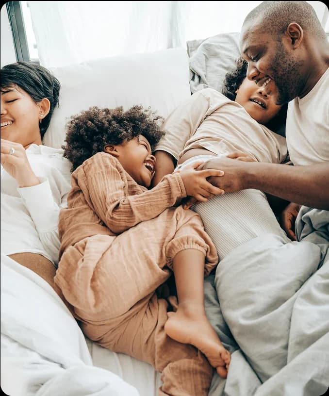 Family cuddling together in bed
